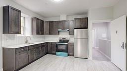 7902 16th Ave, Brooklyn, NY 11214 - kitchen with stainless steel appliances, a sink, and dark brown cabinets
