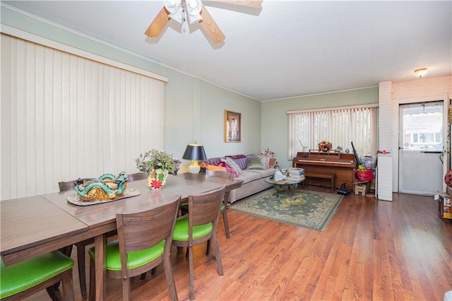 dining area featuring wood finished floors, ornamental molding, and ceiling fan