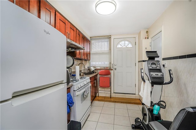 4715 Bedford Ave, Brooklyn, NY 11235 - kitchen with white appliances, under cabinet range hood, and light tile patterned flooring