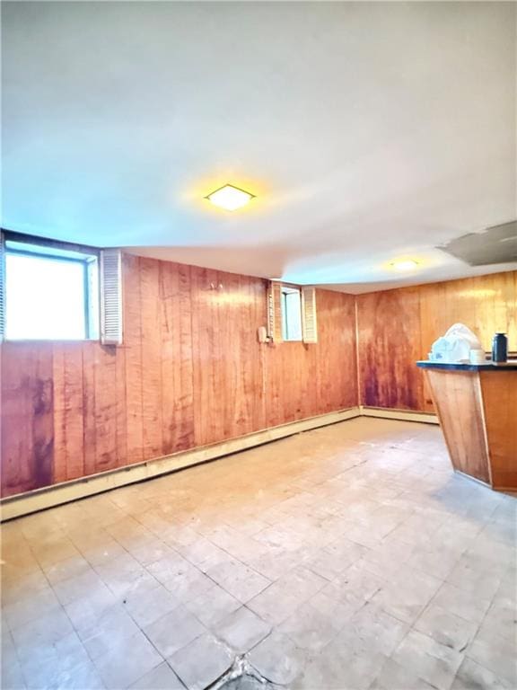 below grade area with healthy amount of natural light, wood walls, and tile patterned floors