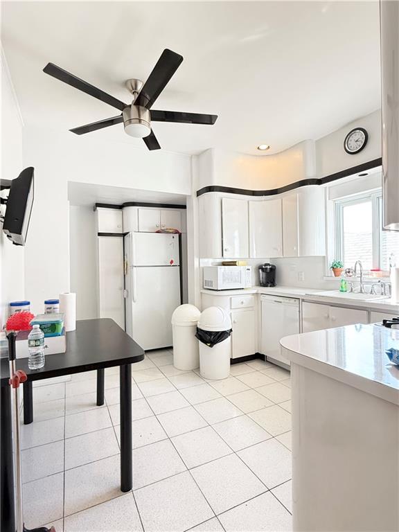 kitchen with white appliances, white cabinetry, light countertops, ceiling fan, and light tile patterned floors