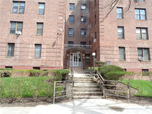 view of building exterior with entry steps and cooling unit