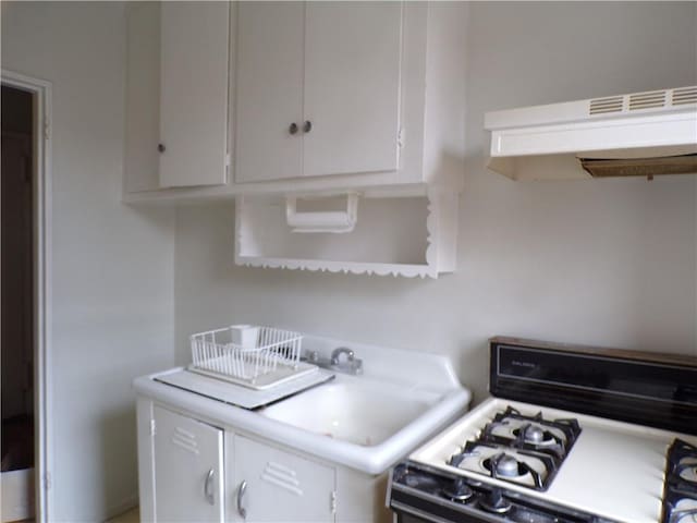 kitchen with light countertops, white cabinets, and white gas range oven