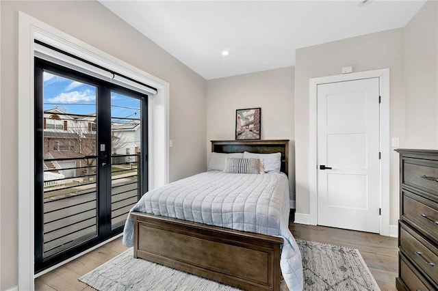 bedroom featuring recessed lighting, baseboards, access to exterior, and wood finished floors