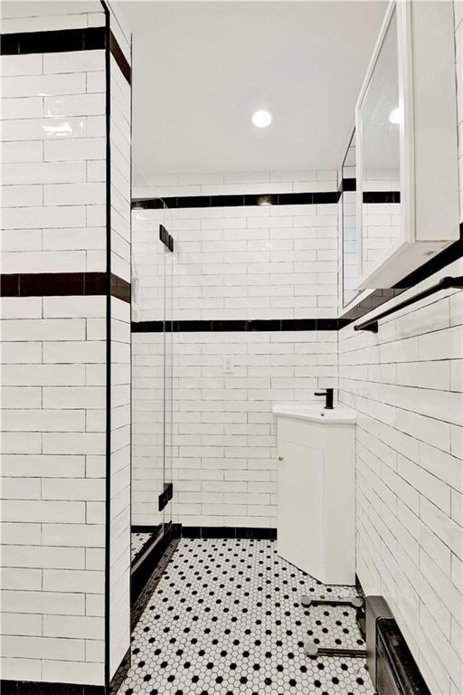 bathroom with recessed lighting, tile patterned floors, tile walls, and a shower stall