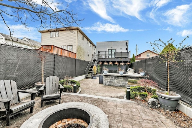 view of patio / terrace with stairway, a fenced backyard, and an outdoor fire pit