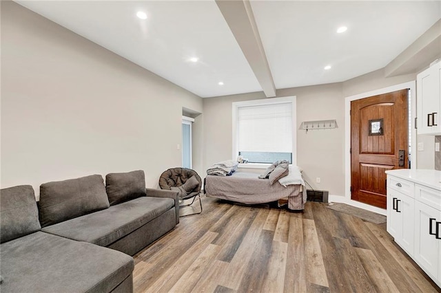living area featuring visible vents, wood finished floors, beamed ceiling, baseboards, and recessed lighting