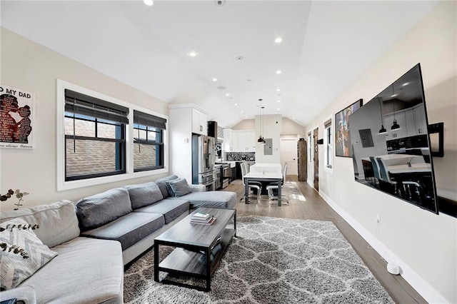living area with light wood-style floors, recessed lighting, baseboards, and lofted ceiling