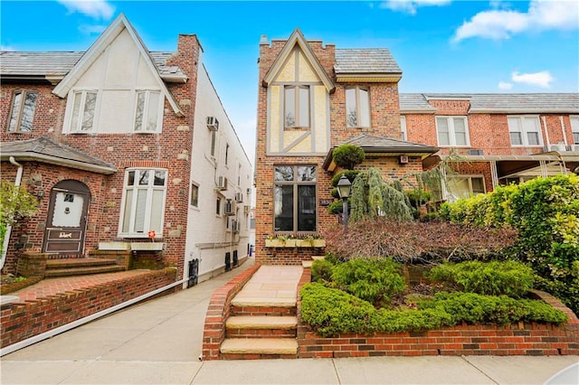 english style home featuring brick siding
