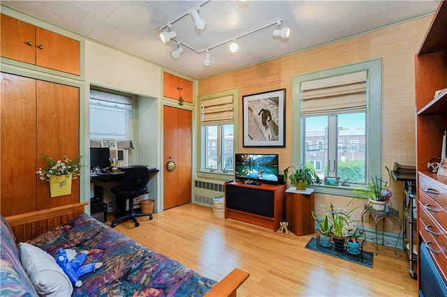 home office featuring radiator heating unit, wood finished floors, and track lighting