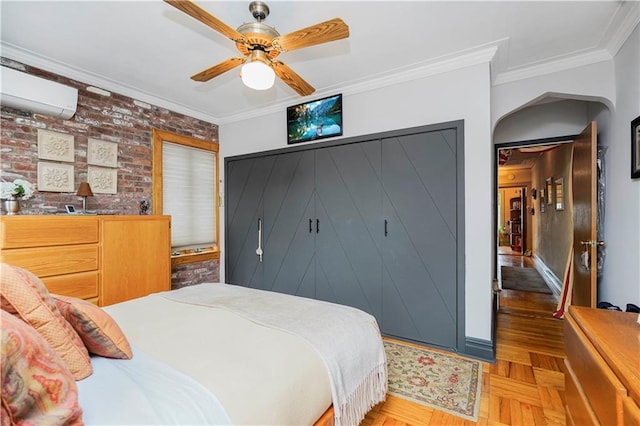 bedroom featuring a wall mounted air conditioner, ornamental molding, brick wall, a closet, and a ceiling fan