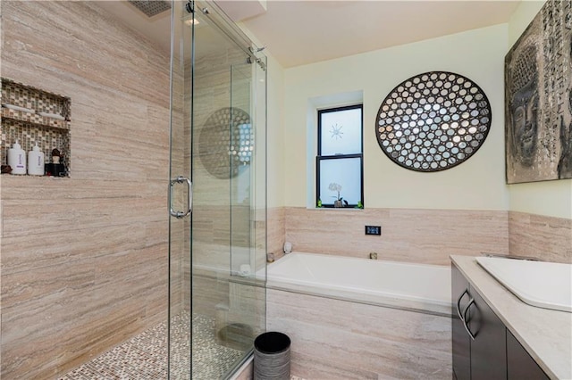 full bathroom with a stall shower, a garden tub, and vanity