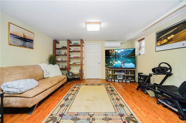 living area featuring wood finished floors and a wall mounted air conditioner