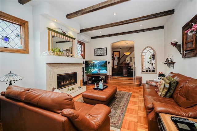 living room with arched walkways, stairway, a wall unit AC, a fireplace, and beamed ceiling
