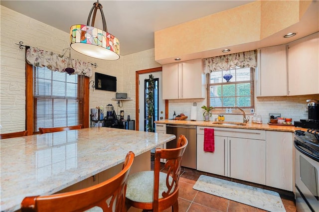 kitchen featuring a sink, appliances with stainless steel finishes, backsplash, and white cabinets