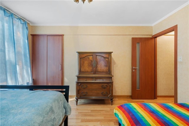 bedroom with crown molding, multiple windows, and light wood-style floors