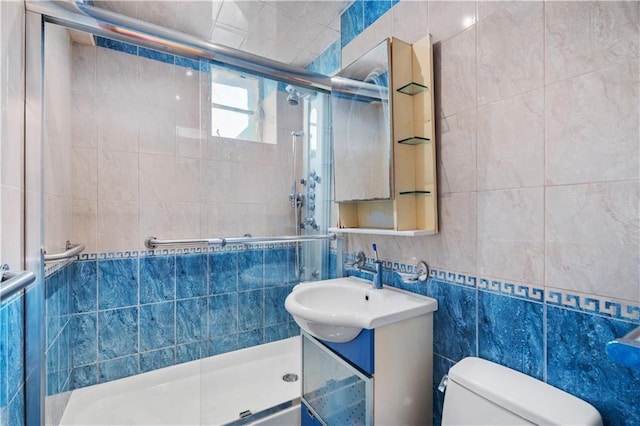 full bath featuring vanity, toilet, tile walls, and a stall shower