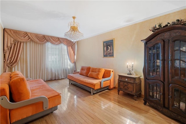 sitting room with an inviting chandelier, ornamental molding, and hardwood / wood-style floors