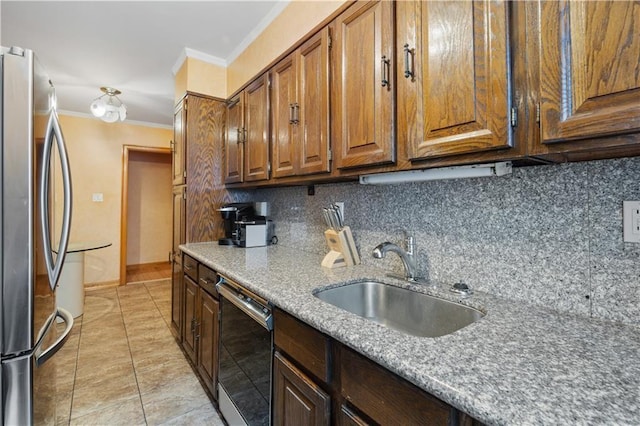 kitchen featuring a sink, dishwasher, freestanding refrigerator, backsplash, and ornamental molding