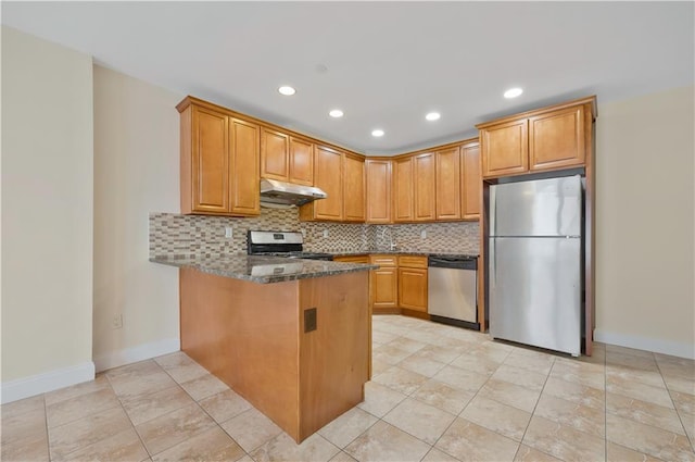 2138 Bath Ave Unit 1A, Brooklyn, NY 11214 - kitchen with stainless steel appliances, under cabinet range hood, a peninsula, backsplash, and dark stone countertops