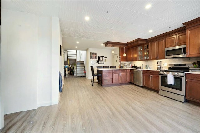 2752 Ocean Ave Unit 6A, Brooklyn, NY 11229 - kitchen with appliances with stainless steel finishes, a peninsula, light wood finished floors, glass insert cabinets, and light countertops