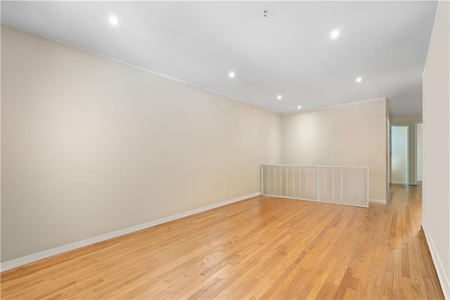 unfurnished room featuring recessed lighting, light wood-type flooring, and baseboards
