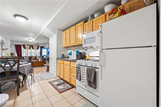 kitchen featuring light brown cabinets, dark countertops, open floor plan, light tile patterned flooring, and white appliances