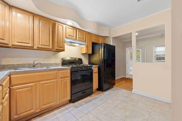 kitchen featuring under cabinet range hood, a sink, light tile patterned flooring, baseboards, and black appliances