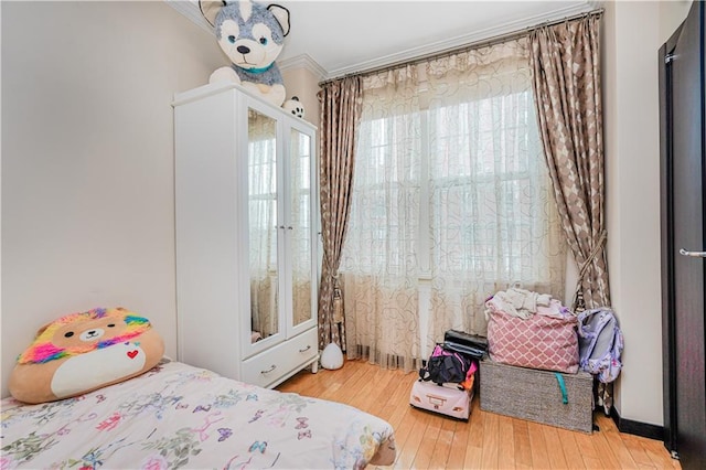 bedroom featuring wood finished floors and crown molding