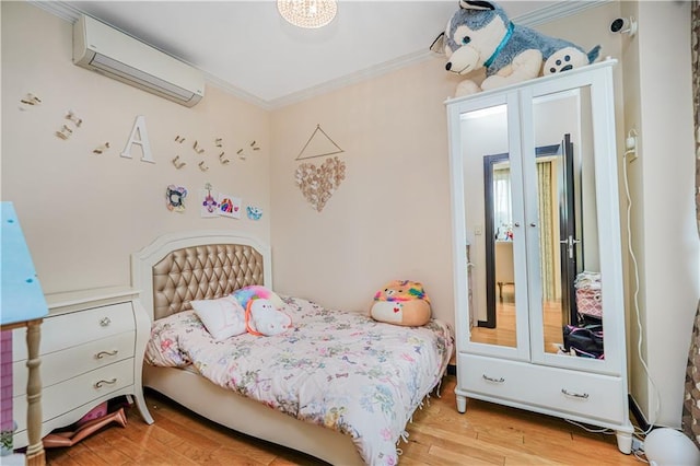 bedroom featuring wood finished floors, a wall unit AC, and ornamental molding