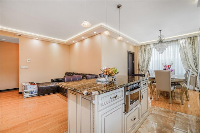45 Oceana Dr E Unit 4B, Brooklyn, NY 11235 - kitchen featuring oven, a raised ceiling, a chandelier, dark stone countertops, and decorative light fixtures