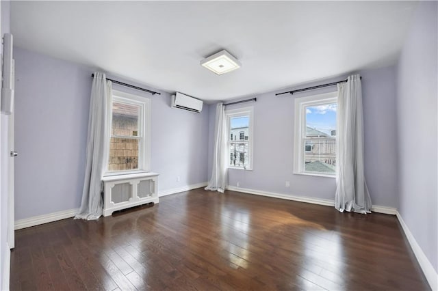 unfurnished room featuring hardwood / wood-style floors, radiator heating unit, baseboards, and a wall mounted air conditioner