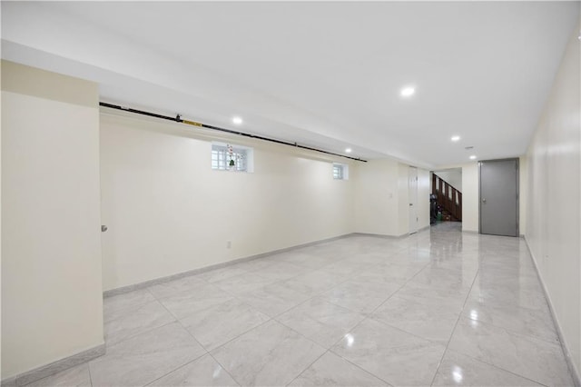basement featuring recessed lighting, baseboards, stairs, and marble finish floor