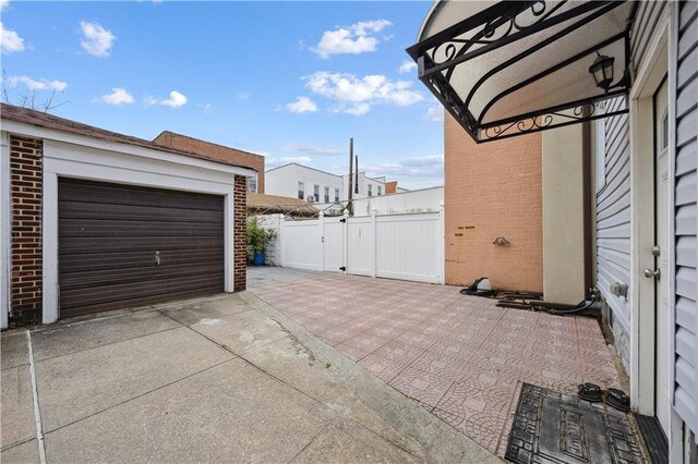 view of property exterior with concrete driveway, brick siding, fence, and a garage