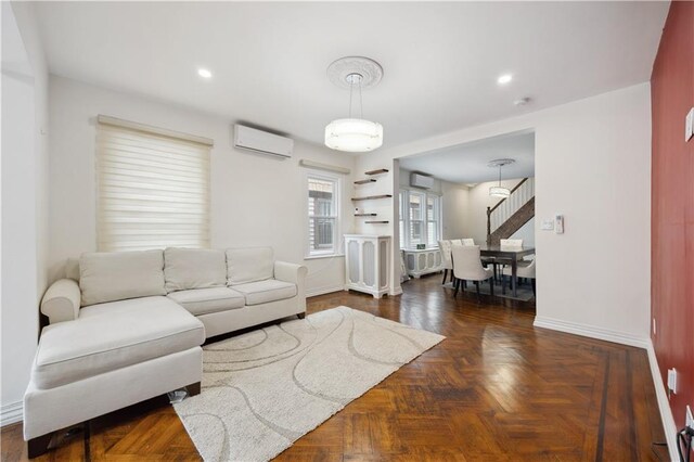 living room featuring an AC wall unit and baseboards