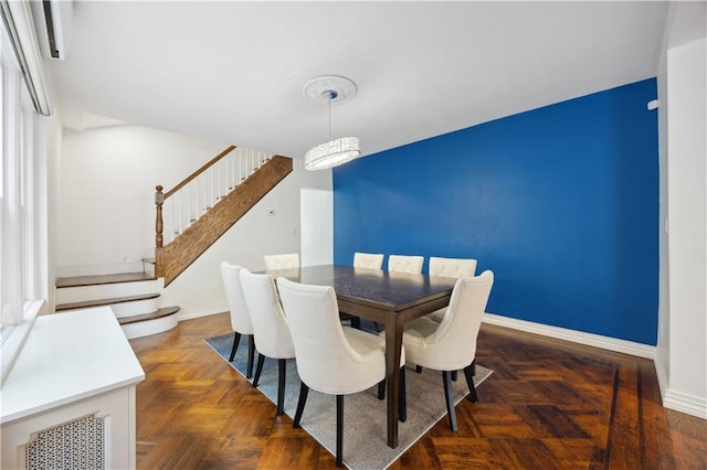 dining space featuring baseboards and stairs