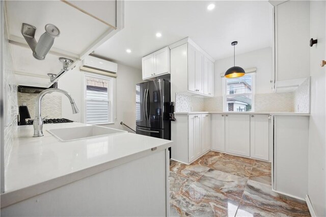 kitchen with freestanding refrigerator, a wall mounted AC, marble finish floor, and tasteful backsplash