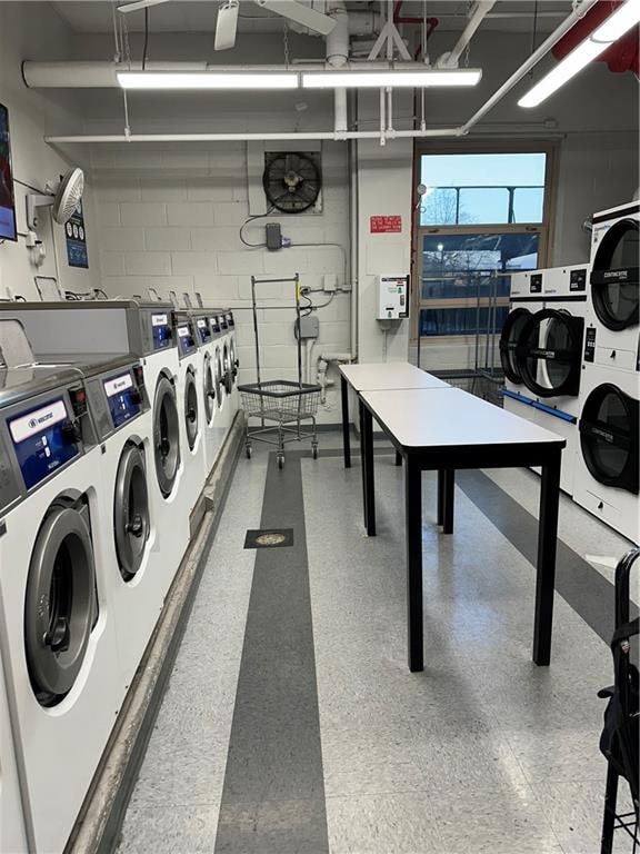 shared laundry area featuring concrete block wall and separate washer and dryer