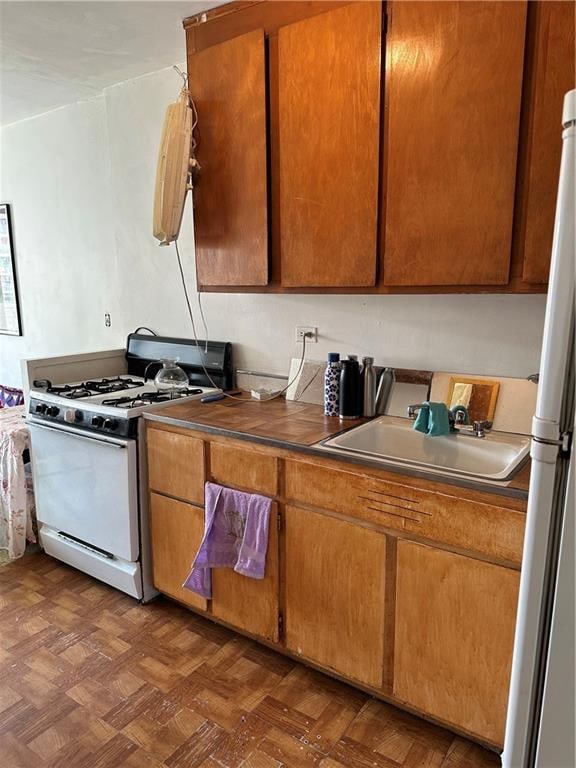 464 Neptune Ave Unit 15A, Brooklyn, NY 11224 - kitchen with white appliances, a sink, and brown cabinets