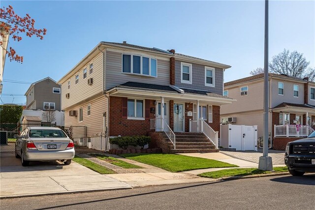 74 E Brandis Ave, Staten Island, NY 10308 - view of front facade featuring a gate, brick siding, and covered porch