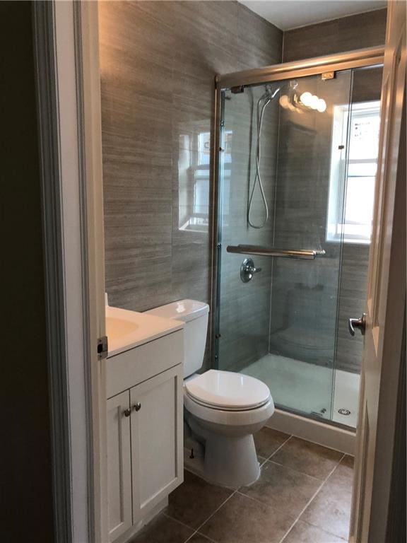 1462 66th St, Brooklyn, NY 11219 - full bathroom featuring a shower stall, tile patterned floors, vanity, tile walls, and toilet