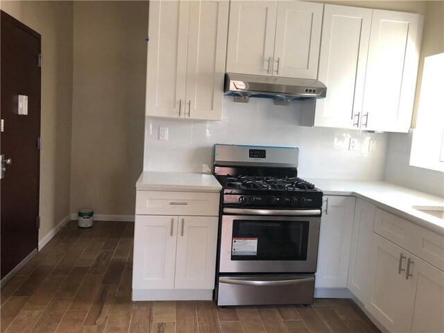 1462 66th St, Brooklyn, NY 11219 - kitchen with gas range, white cabinetry, light countertops, baseboards, and under cabinet range hood