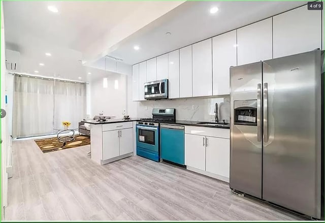 2503 Ocean Ave Unit 3B, Brooklyn, NY 11229 - kitchen with appliances with stainless steel finishes, a sink, dark countertops, white cabinets, and light wood-style floors