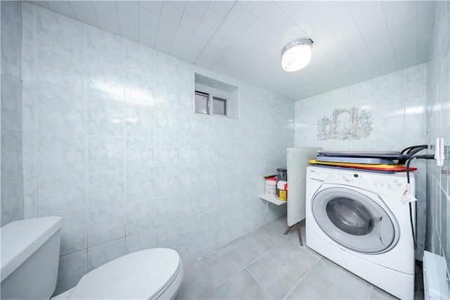 half bath featuring washer / clothes dryer, tile walls, toilet, and tile patterned floors