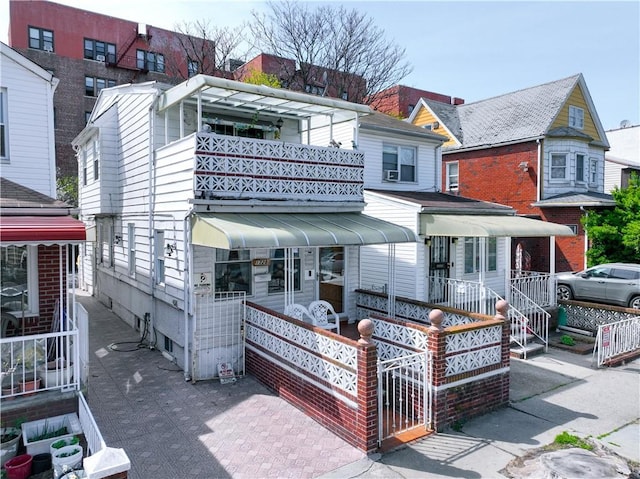 back of house with a balcony and covered porch