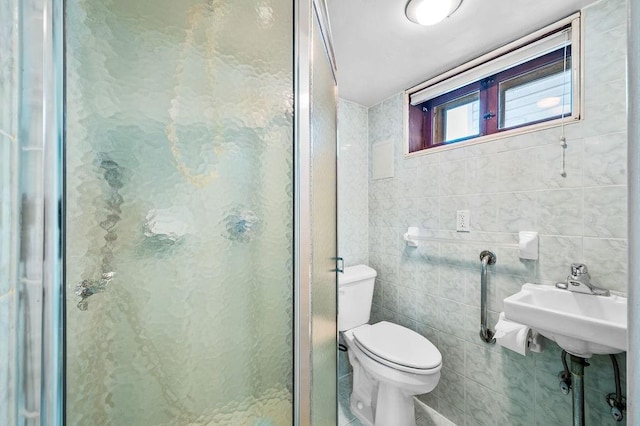 full bath with a shower stall, toilet, tile walls, and a sink