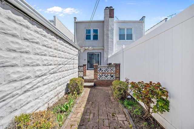 back of property featuring stucco siding and a chimney