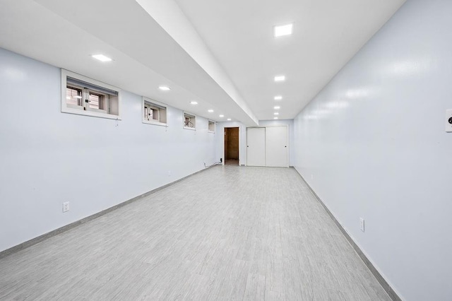 finished below grade area featuring recessed lighting, light wood-style floors, and baseboards