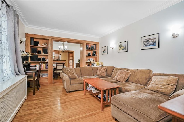 living area with a chandelier, ornamental molding, and light wood-style floors