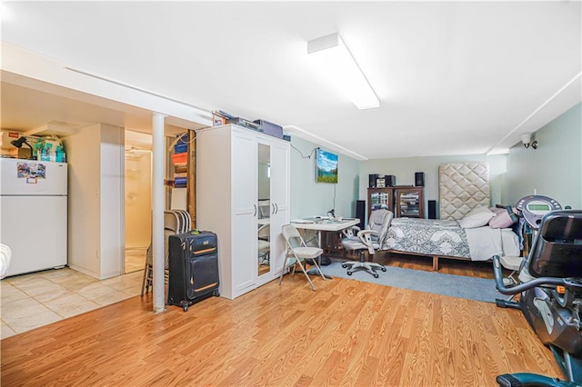 bedroom featuring freestanding refrigerator and wood finished floors